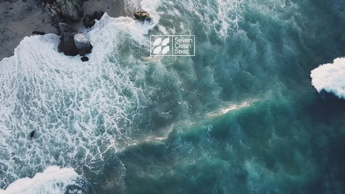 Aerial drone view of turquoise ocean waves with Casa del Agua logo overlay