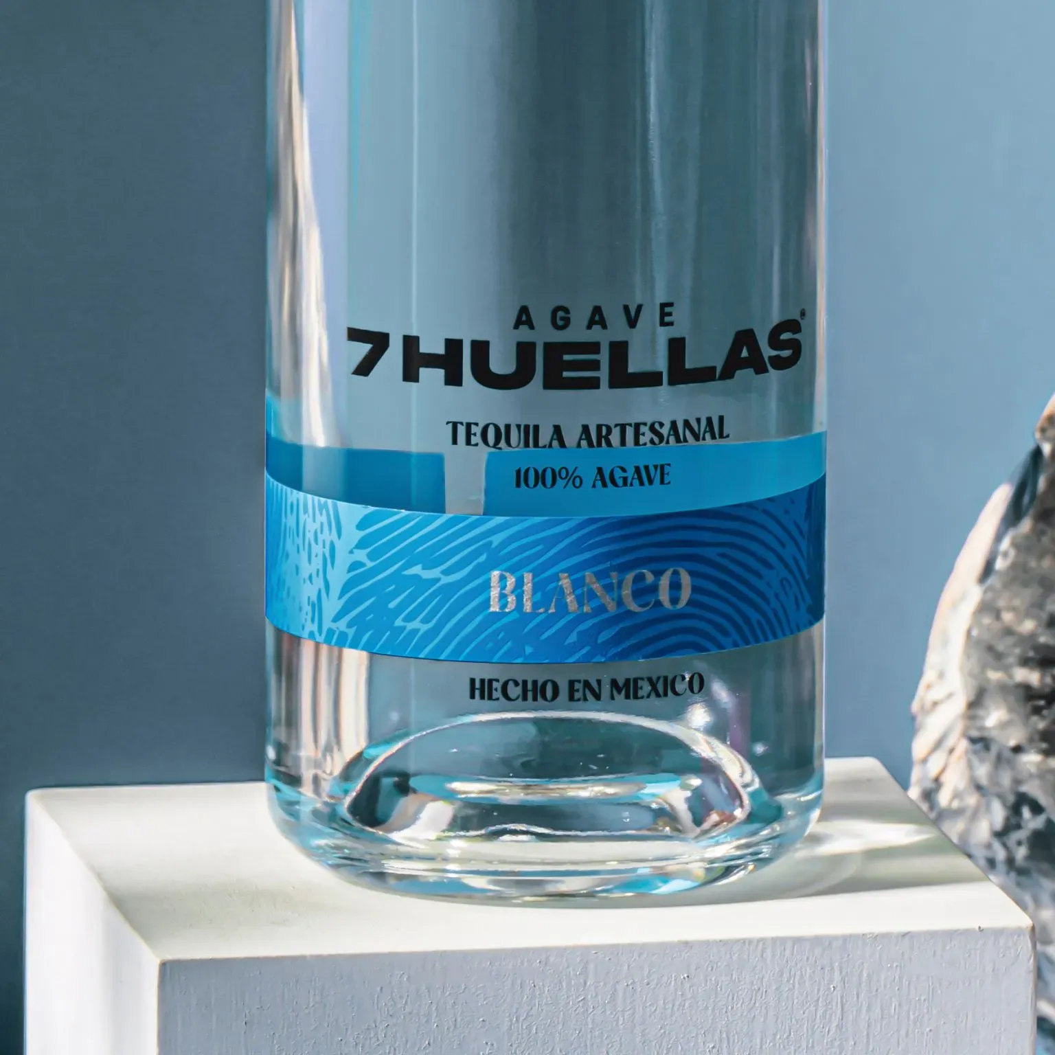 Blanco bottle label on white pedestal with blue background