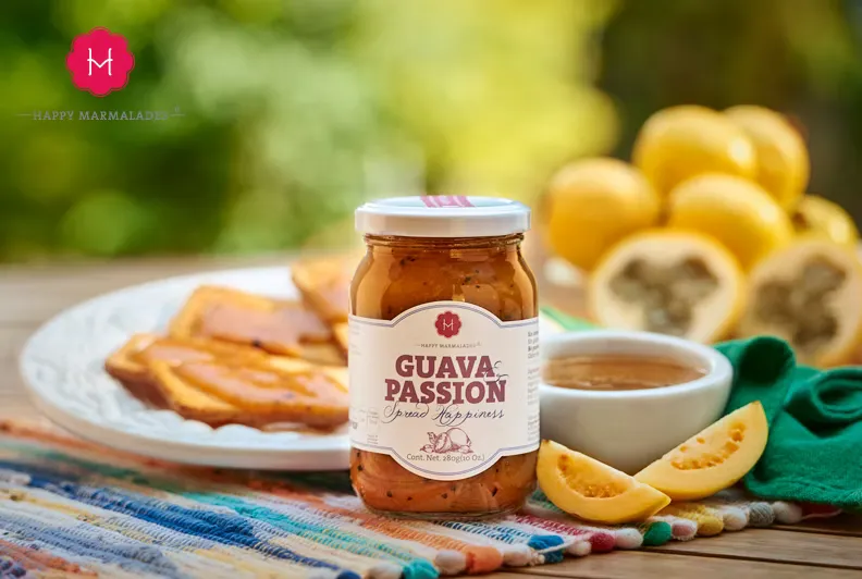 Guava Passion jar in garden setting with toast, orange slices, and guavas