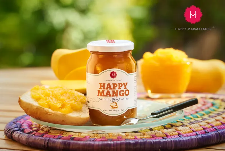 Happy Mango jar on colorful woven placemat with mango slices and spread on bread
