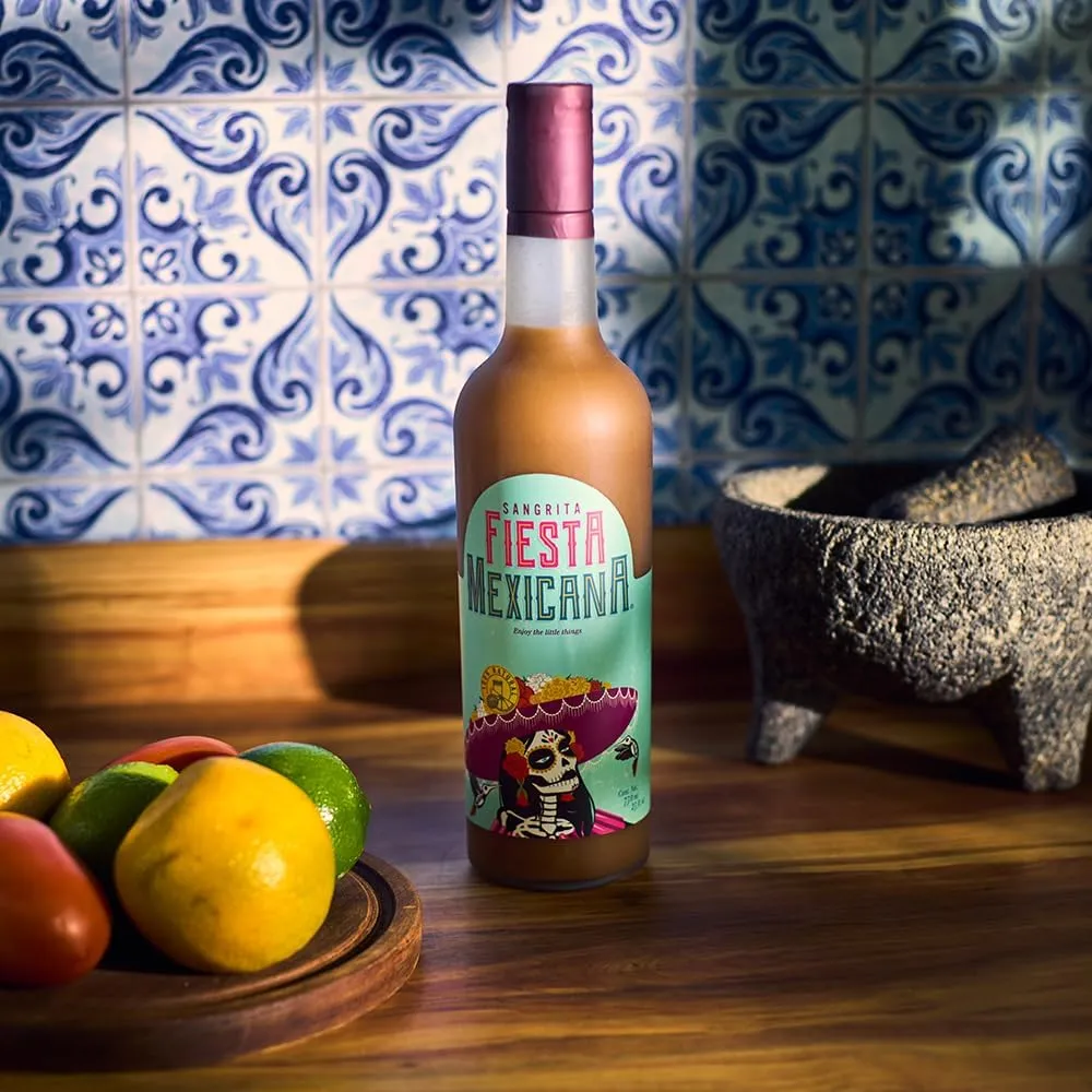 Sangrita bottle on walnut counter with Talavera tiles, molcajete, and citrus