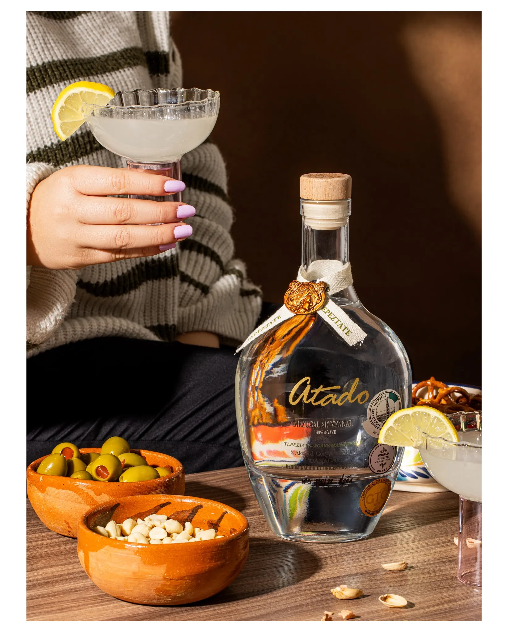 Tepeztate bottle with margarita, olives, and peanuts at bar table
